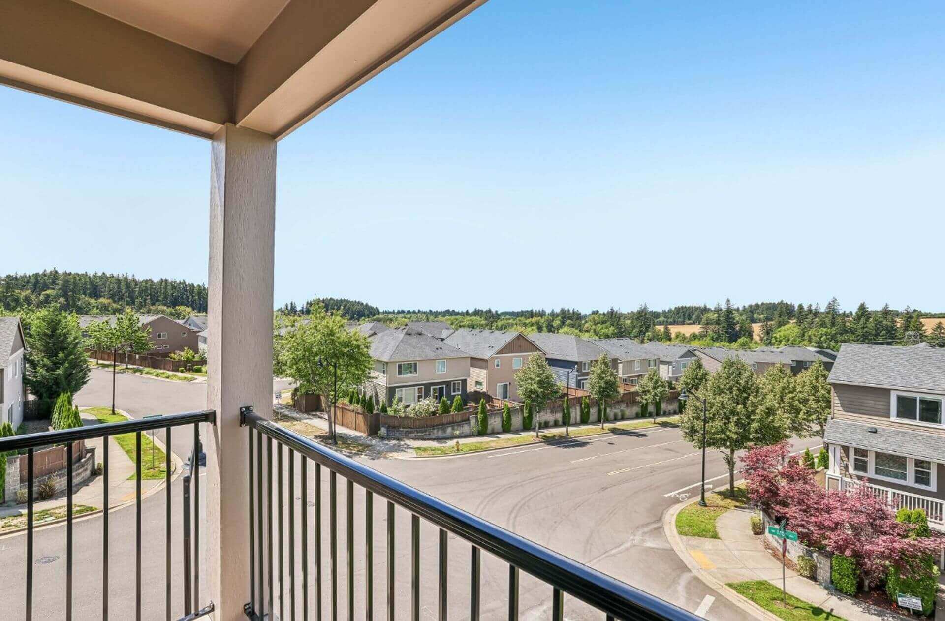 Private covered balcony with outdoor seating and scenic green views at Abbey Creek Square