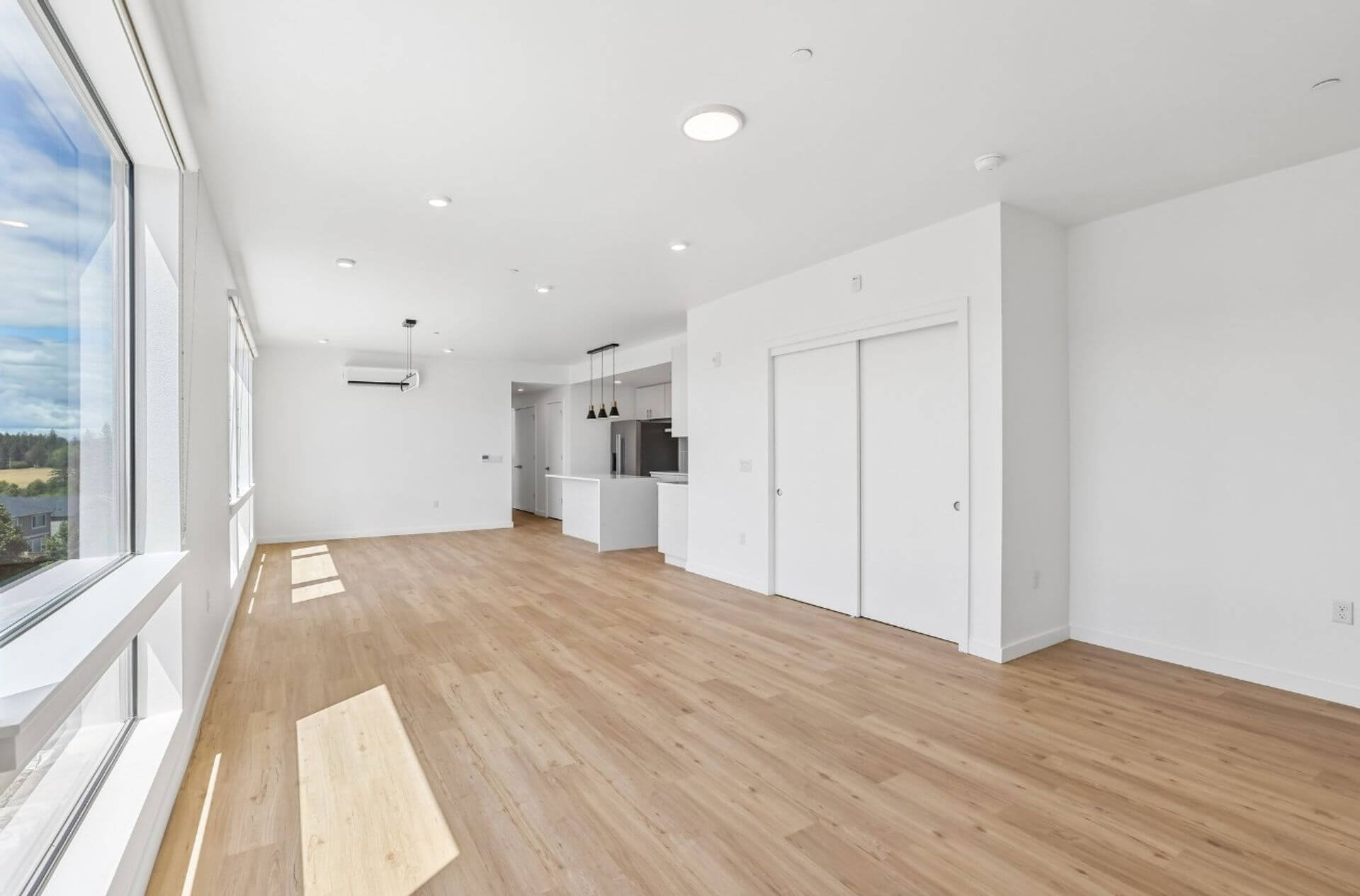 Open living and dining area with multi-split heating and cooling unit and floor-to-ceiling windows