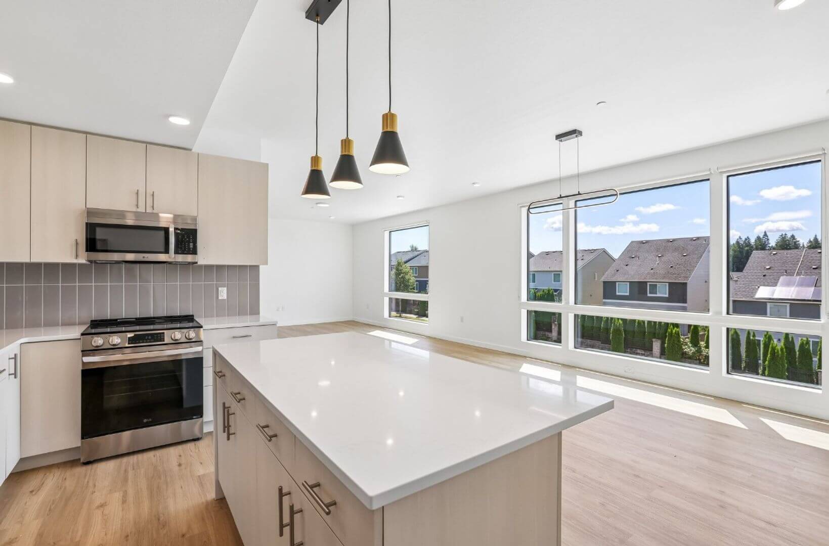 Open-concept kitchen and living area with large windows