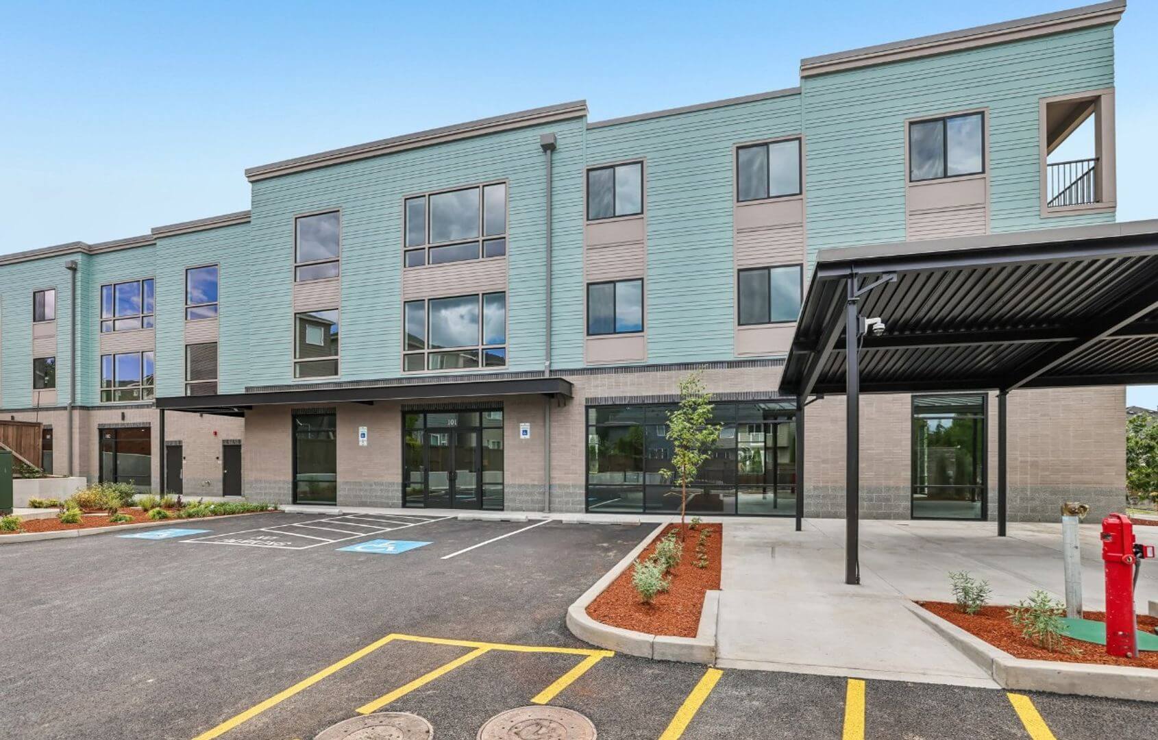 Building exterior with covered breezeway and ground-floor shop entrances