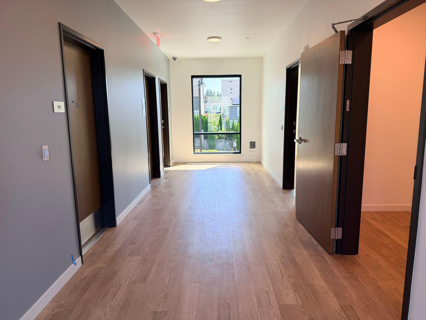 Interior hallway leading to a window with hillside views