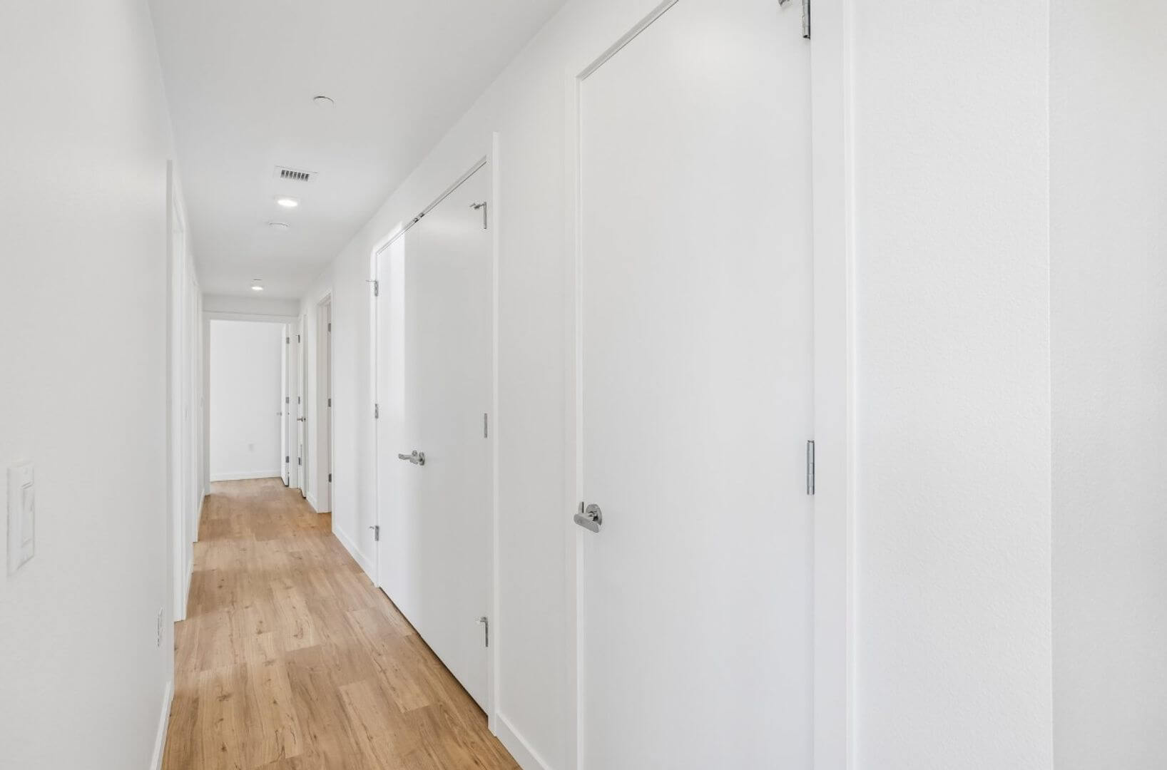 Interior hallway with bedroom and closet doors